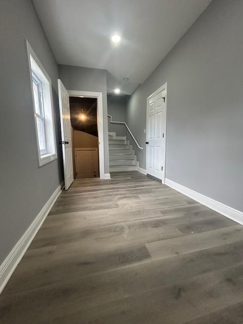 interior space with baseboards, stairway, and wood finished floors