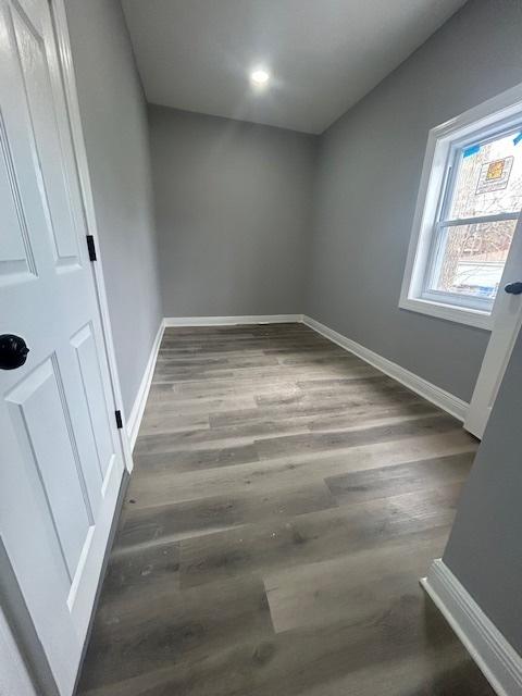 unfurnished room with wood finished floors and baseboards