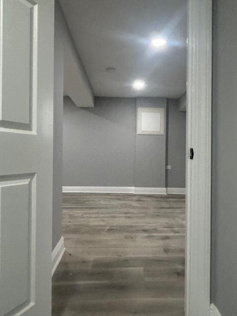 finished basement featuring wood finished floors and baseboards