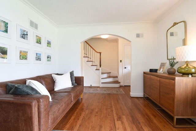 living room with crown molding, arched walkways, visible vents, and dark wood-style floors