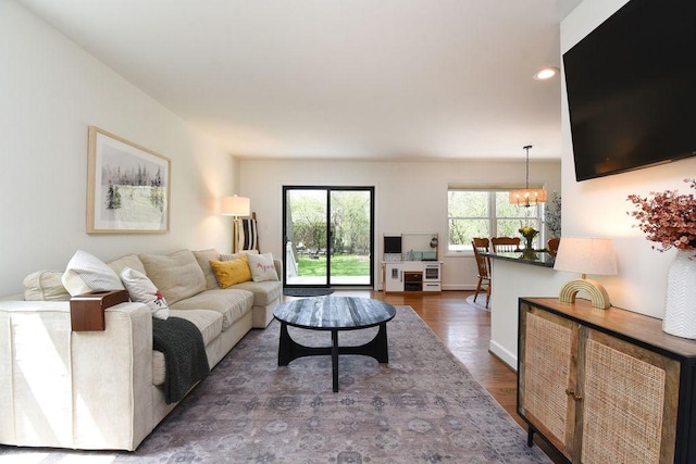 living room with baseboards, recessed lighting, wood finished floors, and a chandelier