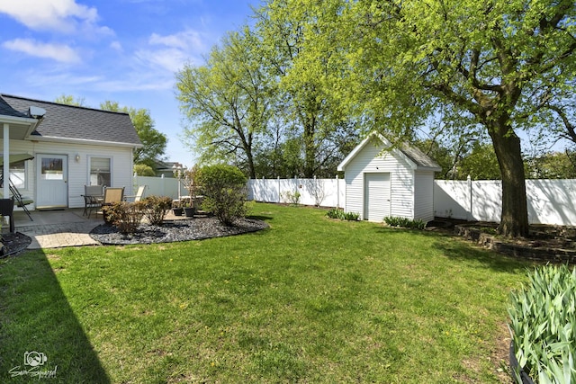 view of yard with an outbuilding, a storage shed, a patio, and a fenced backyard