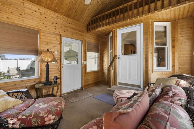 carpeted living room with wood walls, lofted ceiling, and wood ceiling