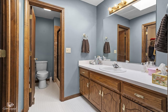 full bathroom with toilet, a stall shower, vanity, and baseboards