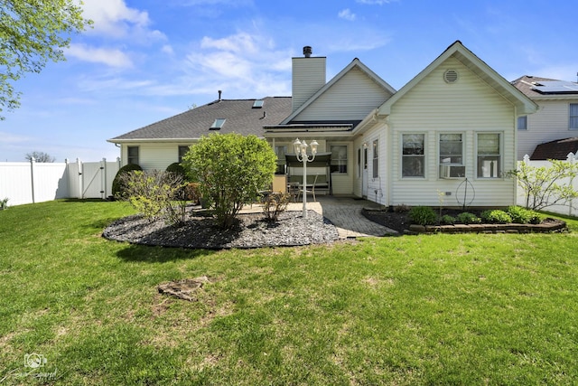 rear view of house with a patio area, a yard, cooling unit, a chimney, and fence