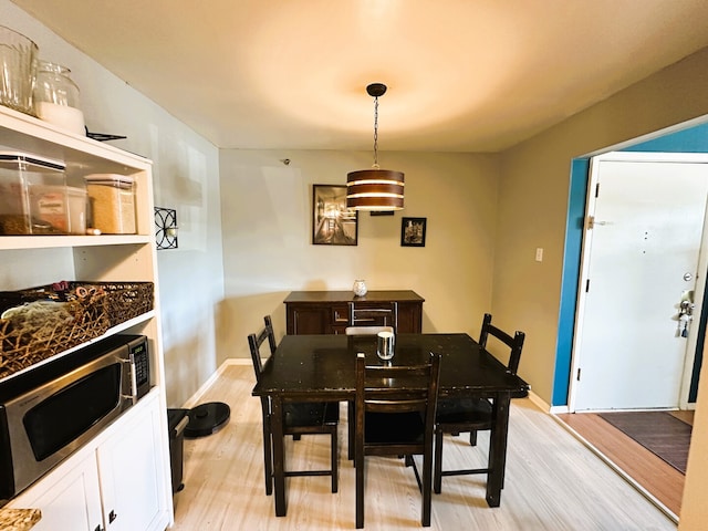 dining area featuring light wood-style floors and baseboards