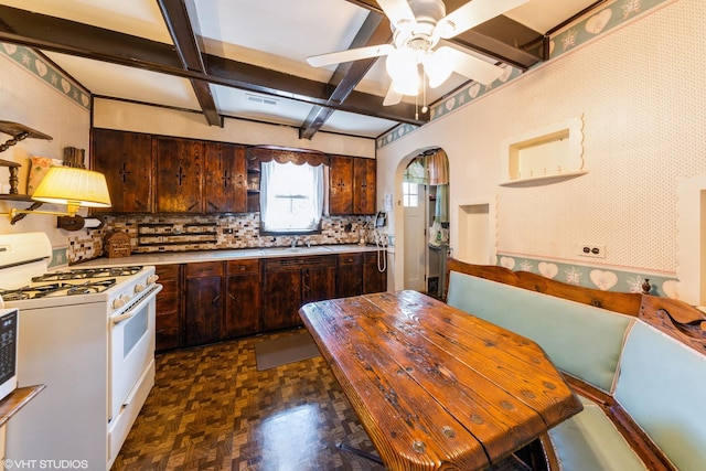 635 N Greenleaf St, Gurnee, IL 60031 - kitchen with dark brown cabinetry, ceiling fan, white range with gas stovetop, light countertops, and arched walkways