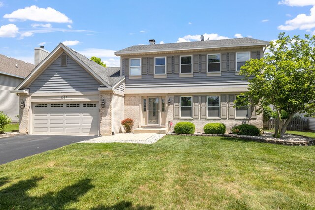 1267 Churchill Rd, Bartlett, IL 60103 - view of front facade with brick siding, driveway, a garage, and a chimney
