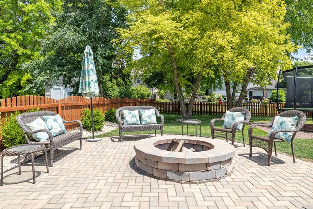 1267 Churchill Rd, Bartlett, IL 60103 - fenced backyard with a trampoline, a patio area, and an outdoor living space with a fire pit