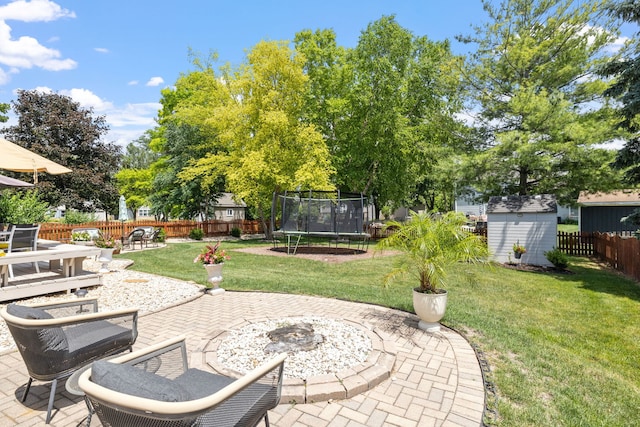 1267 Churchill Rd, Bartlett, IL 60103 - fenced backyard featuring a patio, a storage shed, a trampoline, and an outdoor fire pit