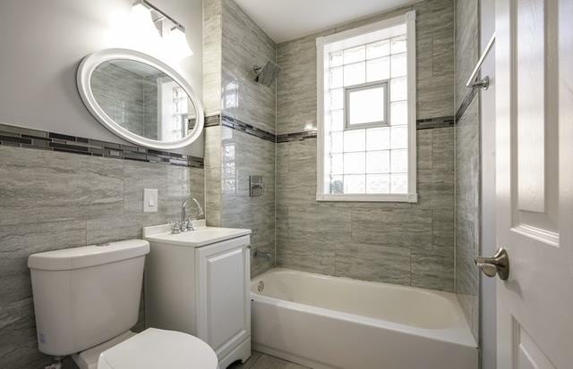 162 N La Crosse Ave, Chicago, IL 60644 - bathroom with a healthy amount of sunlight, shower / bathtub combination, vanity, and toilet