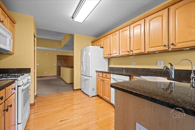 21600 W Larch Dr, Plainfield, IL 60544 - kitchen with a sink, white appliances, dark stone counters, light wood-style flooring, and baseboards