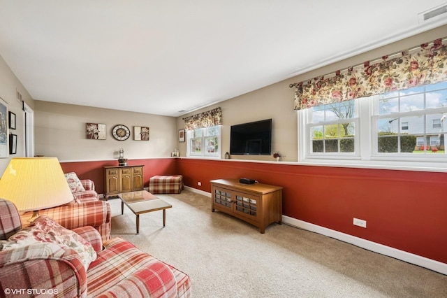 living area with plenty of natural light, carpet flooring, baseboards, and visible vents