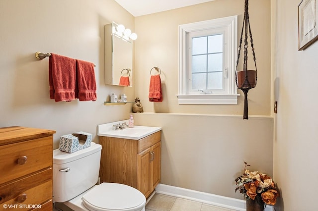 bathroom with vanity, baseboards, tile patterned flooring, and toilet