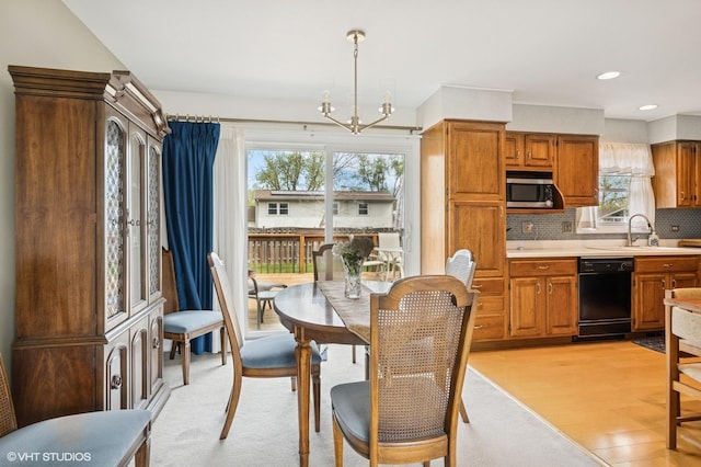dining space with recessed lighting, light wood-style flooring, and a notable chandelier