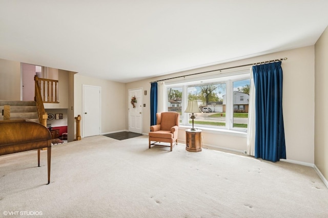 sitting room featuring carpet floors, baseboards, and stairway