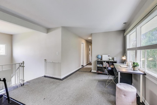 carpeted office featuring baseboards, visible vents, and plenty of natural light
