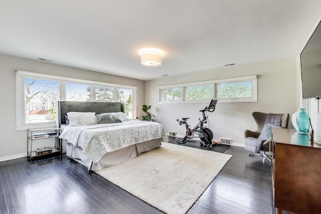 bedroom with baseboards, visible vents, and dark wood-type flooring