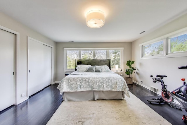 bedroom with dark wood-style flooring, baseboards, and visible vents
