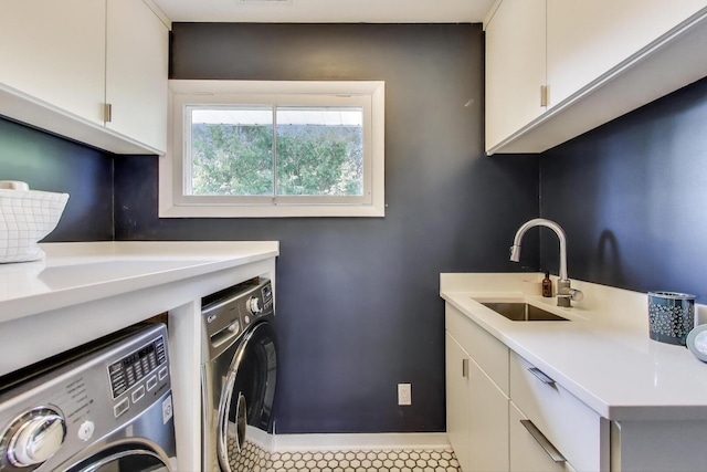 laundry room featuring baseboards, a sink, cabinet space, and independent washer and dryer