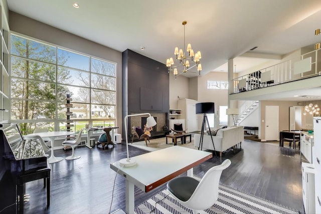 office space with a towering ceiling, wood finished floors, and a notable chandelier