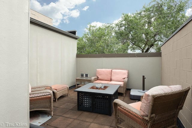 view of patio with an outdoor living space with a fire pit