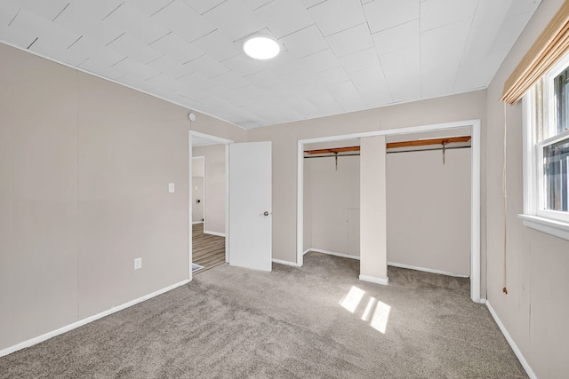 unfurnished bedroom with multiple closets, baseboards, and carpet