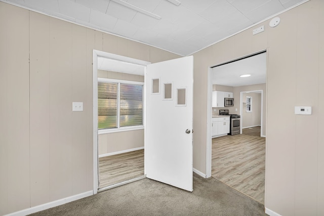 spare room with baseboards and carpet floors