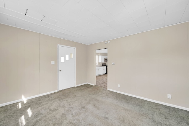 unfurnished living room featuring carpet flooring and baseboards