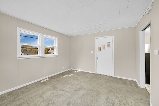 empty room with carpet, visible vents, and baseboards