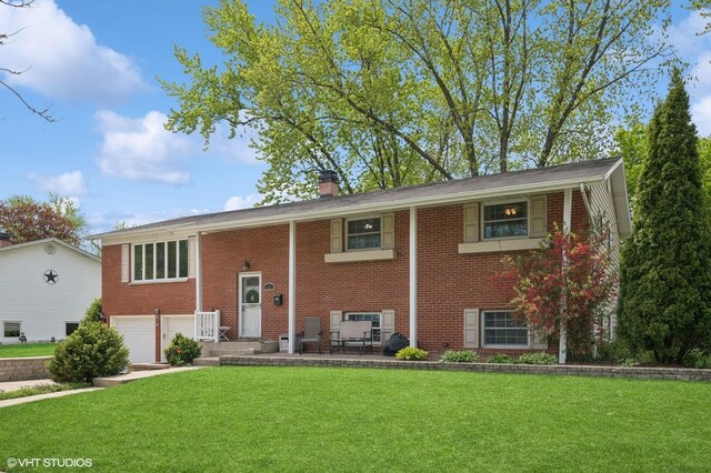 310 N Lytle Dr, Palatine, IL 60074 - raised ranch featuring a garage, brick siding, a front lawn, and a chimney
