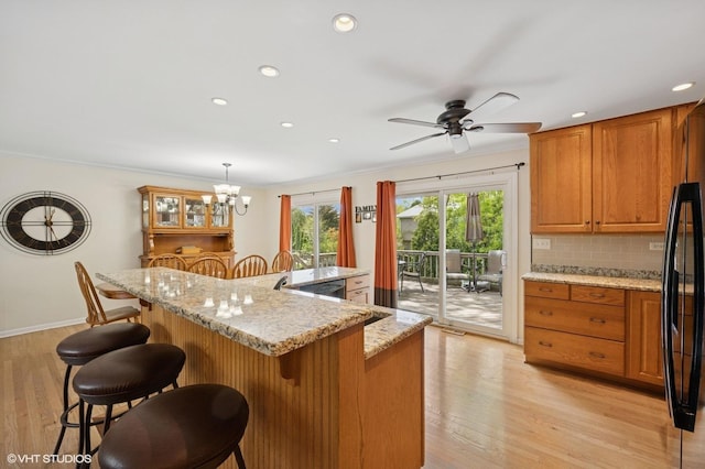 310 N Lytle Dr, Palatine, IL 60074 - kitchen featuring healthy amount of natural light, brown cabinetry, tasteful backsplash, recessed lighting, and a breakfast bar area