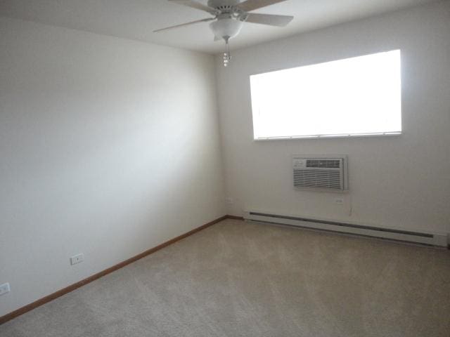 1524 W Sand Bar Ct Unit 2A, Round Lake, IL 60073 - spare room with light carpet, baseboards, a wall mounted AC, a baseboard heating unit, and a ceiling fan