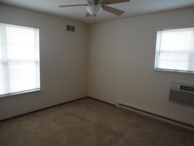 1524 W Sand Bar Ct Unit 2A, Round Lake, IL 60073 - carpeted empty room with a ceiling fan, baseboards, a baseboard radiator, visible vents, and a wall mounted AC