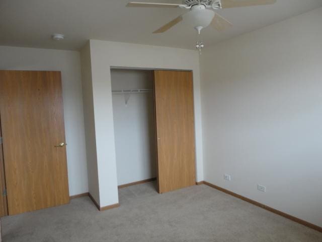 1524 W Sand Bar Ct Unit 2A, Round Lake, IL 60073 - unfurnished bedroom with a closet, baseboards, and light colored carpet