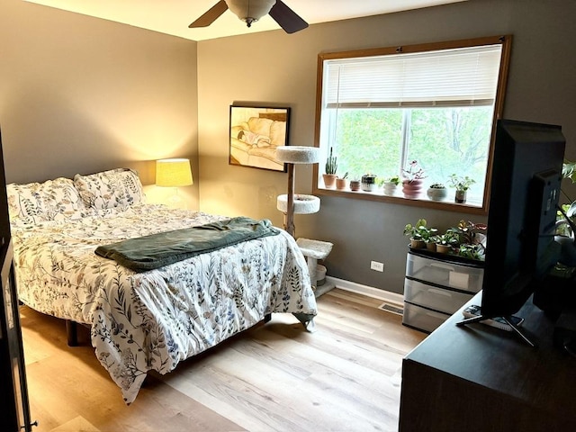 bedroom with baseboards, ceiling fan, and wood finished floors