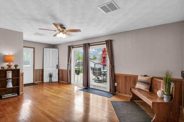 interior space featuring light wood-style flooring, a ceiling fan, and visible vents