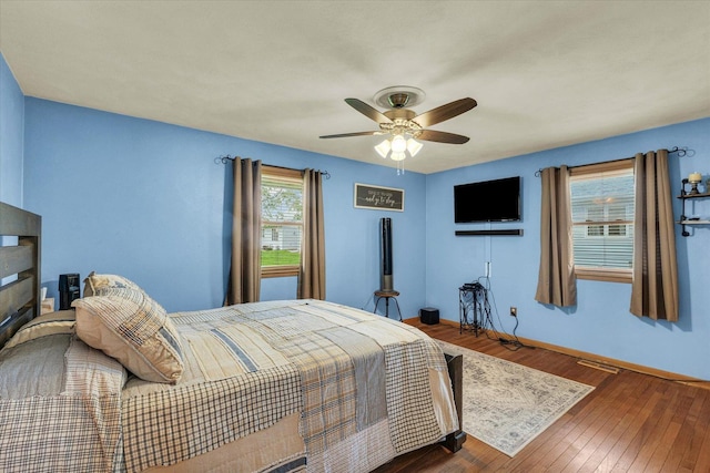 bedroom featuring visible vents, baseboards, a ceiling fan, and wood-type flooring