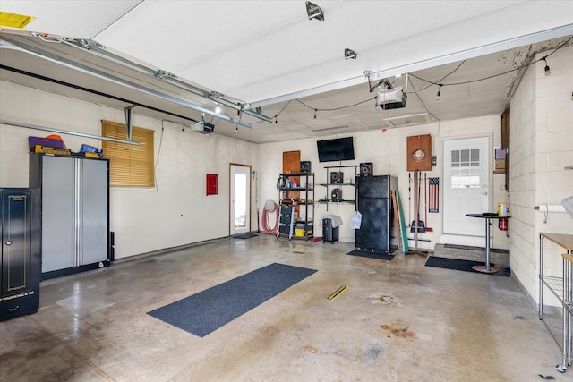 garage with freestanding refrigerator and a garage door opener