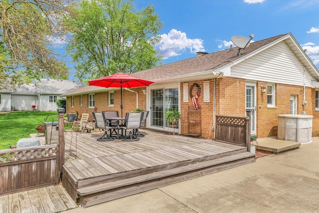 wooden deck featuring a lawn and outdoor dining area