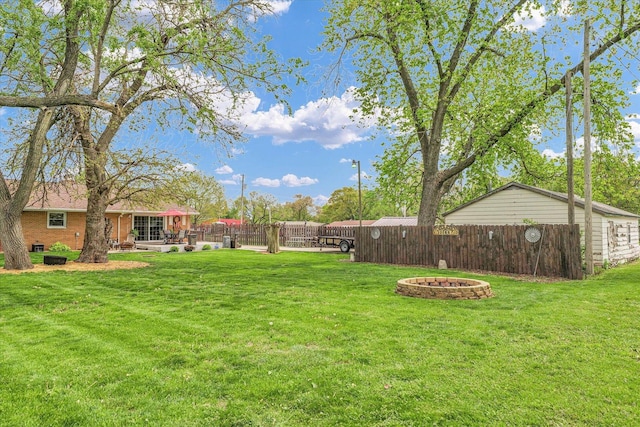 view of yard featuring a fenced backyard, an outdoor fire pit, and a patio area