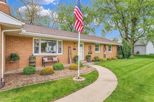 single story home with brick siding and a front yard
