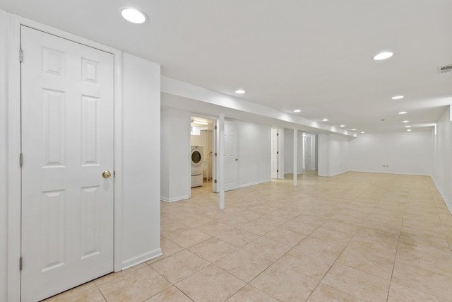 finished below grade area with light tile patterned flooring, washer / clothes dryer, recessed lighting, baseboards, and visible vents