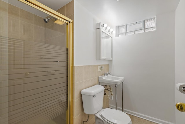 bathroom with toilet, tile walls, a shower stall, and a sink