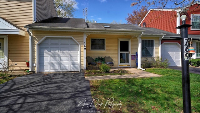 townhome / multi-family property featuring a garage, driveway, and a front yard