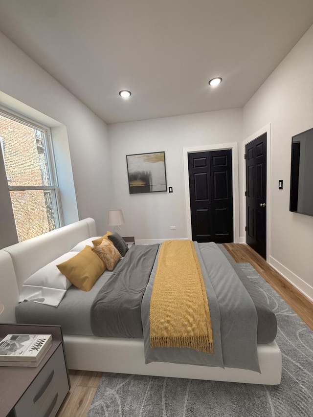 bedroom featuring wood finished floors, recessed lighting, and baseboards