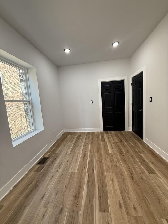 empty room with visible vents, recessed lighting, light wood finished floors, and baseboards