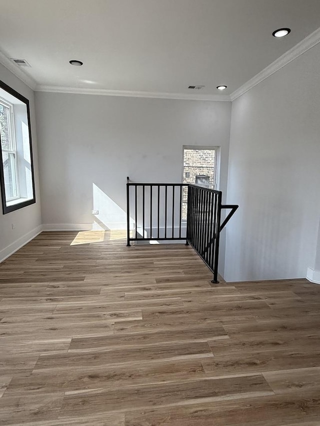 empty room with visible vents, a wealth of natural light, and wood finished floors
