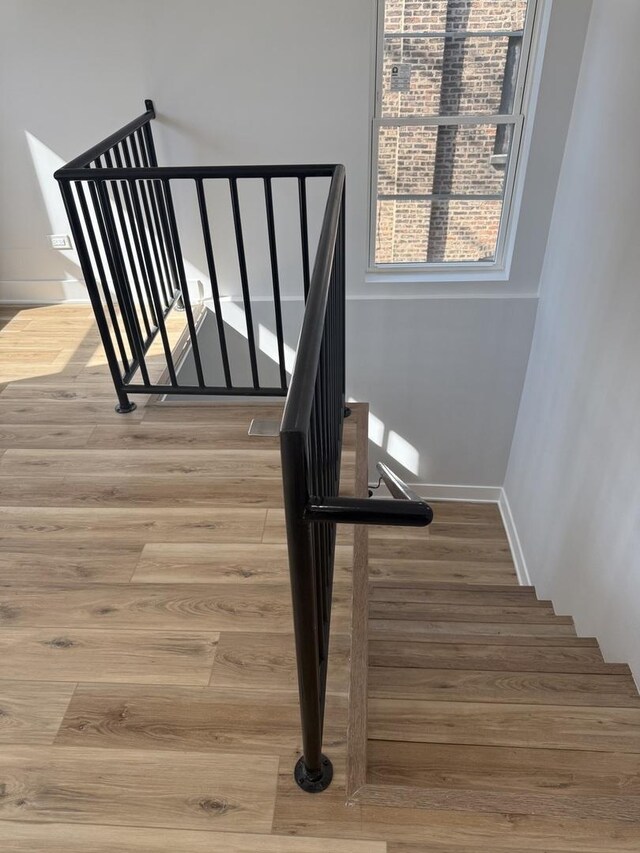 stairway featuring baseboards and wood finished floors
