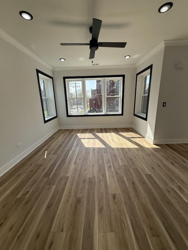 spare room featuring baseboards, recessed lighting, wood finished floors, and ornamental molding